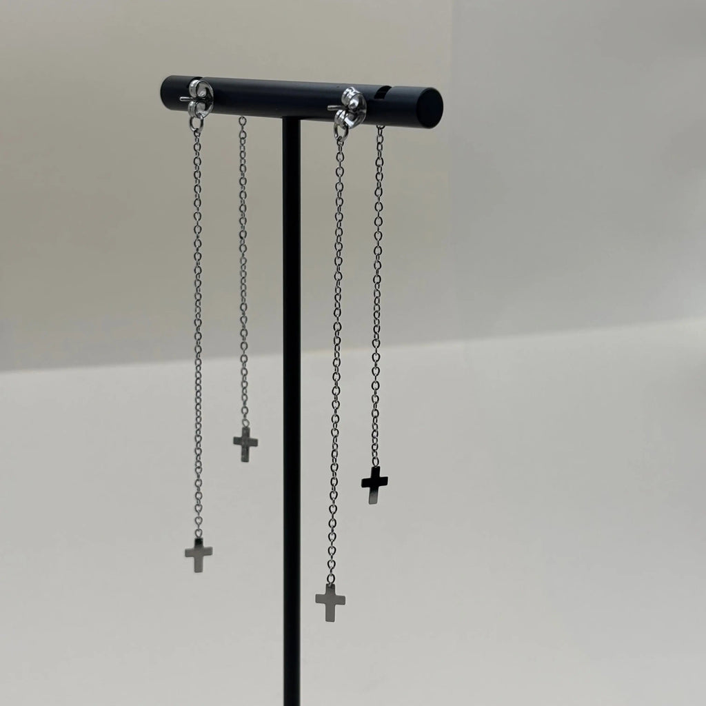 Des boucles d'oreilles avec des petites croix sur base de brillants en argenté en acier inoxydable