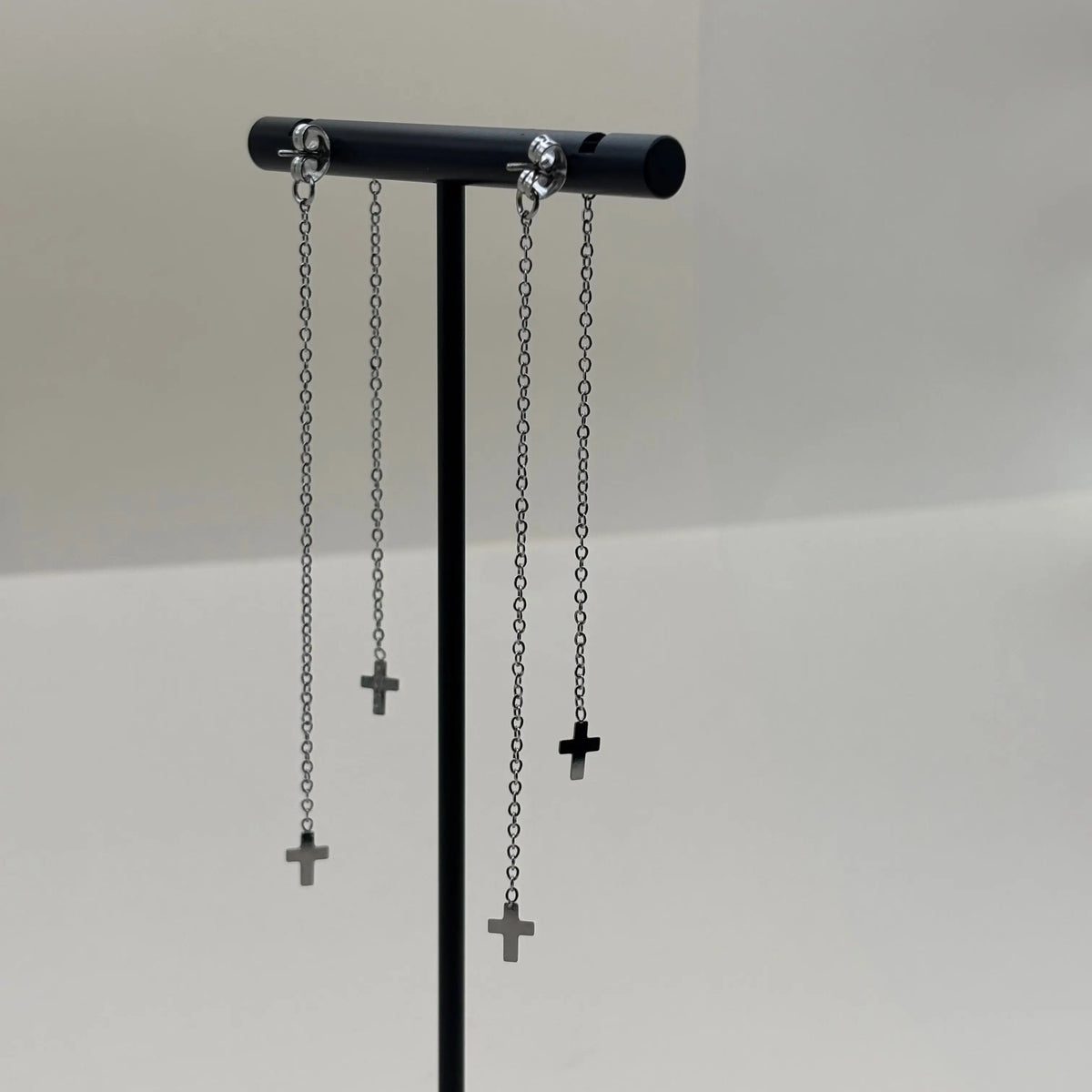 Des boucles d'oreilles avec des petites croix sur base de brillants en argenté en acier inoxydable