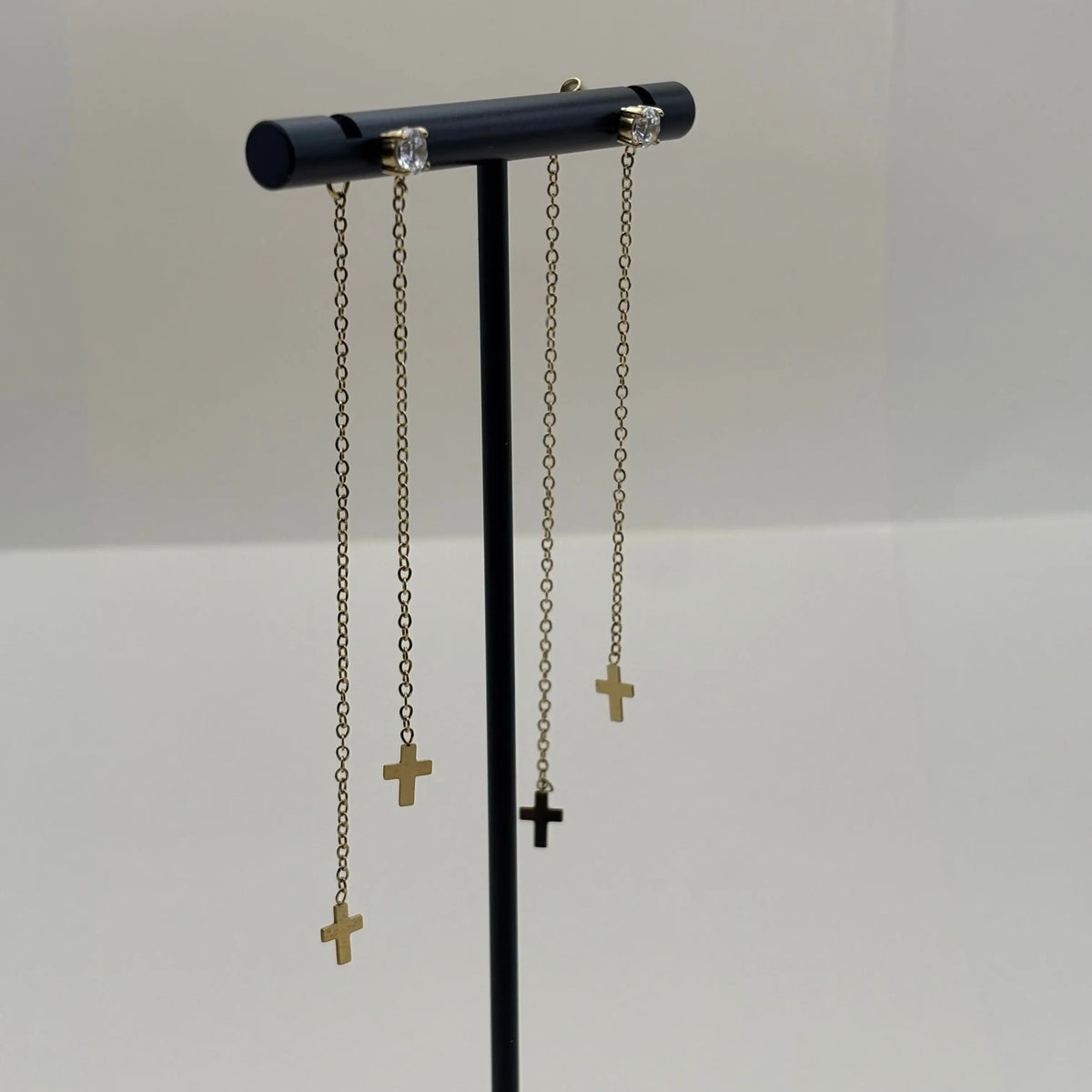 Des boucles d'oreilles avec des petites croix sur base de brillants en doré en acier inoxydable