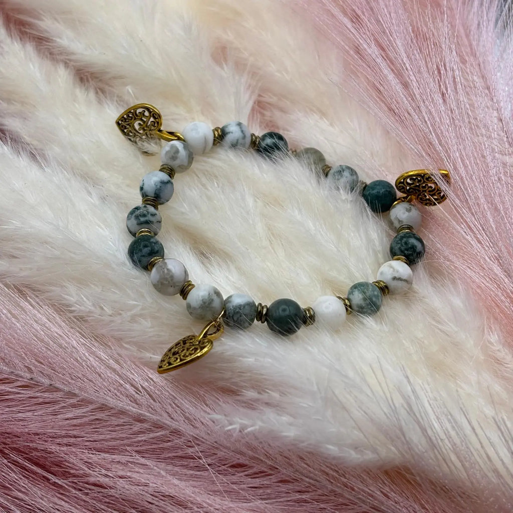 Bracelet en perles artisanal avec breloques cœurs dorés et perles naturelles marbrées vertes sur élastique