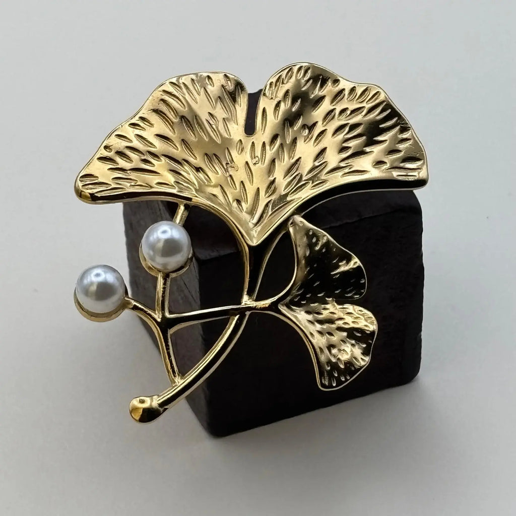 Broche dorée en forme de feuille dorée et deux perles 