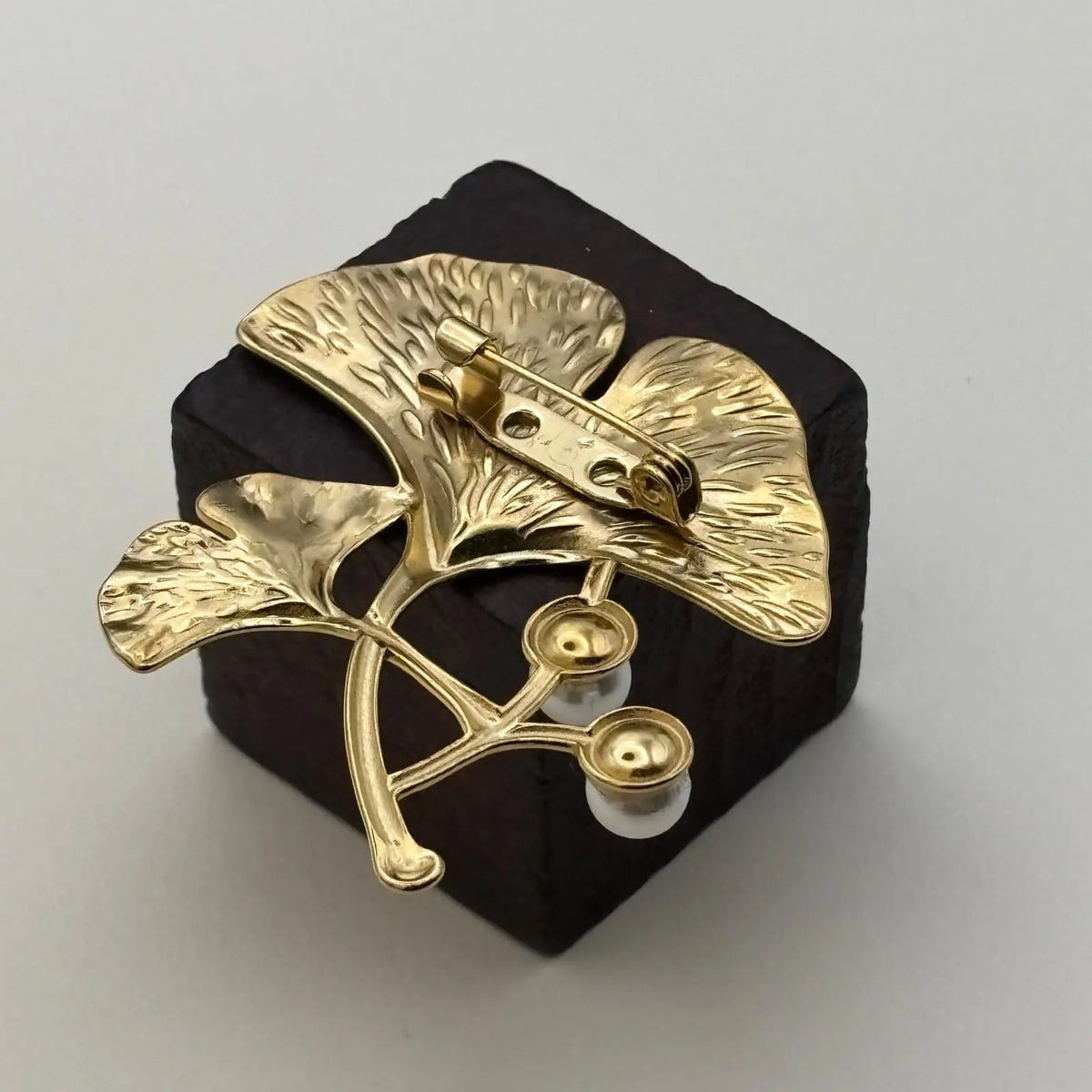 Broche de couleur dorée en forme de feuille dorée et deux perles 