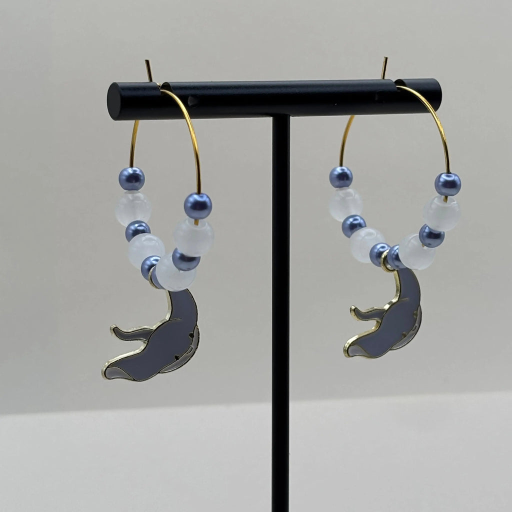 Des boucles d'oreilles créoles dorées avec breloque raie 