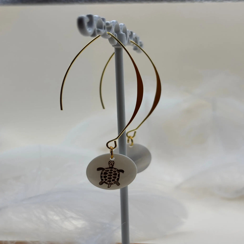 Paire de boucles d'oreilles pendentif avec une pastille nacrée et dessin d'une tortue