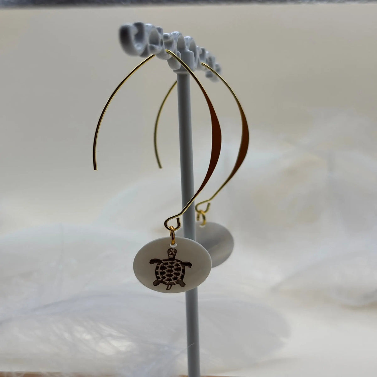 Paire de boucles d'oreilles pendentif avec une pastille nacrée et dessin d'une tortue