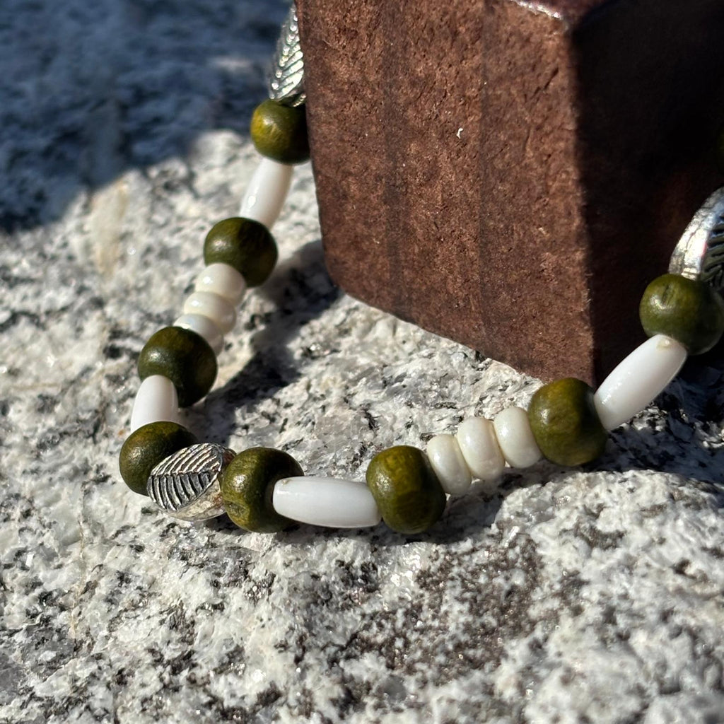 Bracelet en perles artisanal avec des perles feuilles argentées et en bois sur élastique