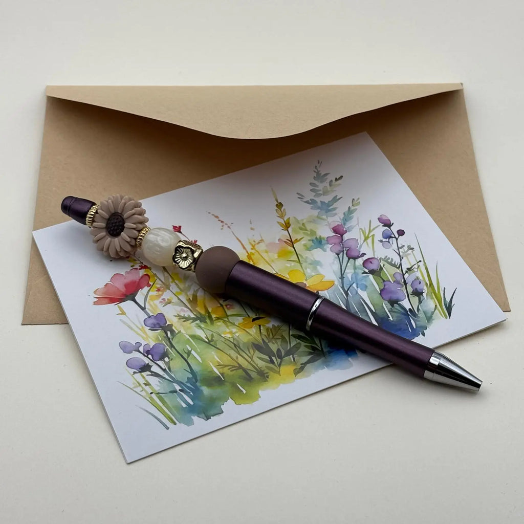 Stylo à bille à mine noire avec breloque en forme de marguerite et perles de verre colorées