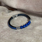 Bracelet homme
Sur lien tressé noir en simili cuir perles bleues