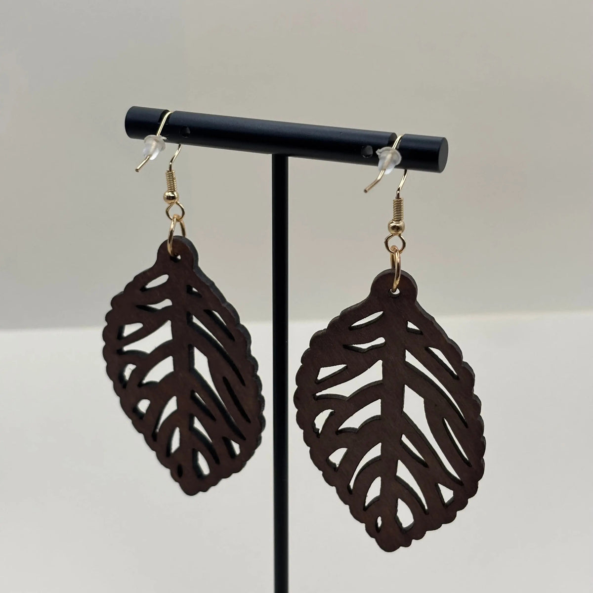 Des boucles d'oreilles fantaisie attache dorée avec boucle en bois motif de feuille