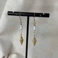 Boucles d'oreilles pendentif dorées avec perles plates blanches et breloque dorée rose des vents vendu sur le site internet prêtes à briller