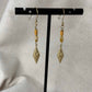 Boucles d'oreilles pendentif dorées avec perles plates oranges et breloque dorée rose des vents vendu sur le site internet prêtes à briller