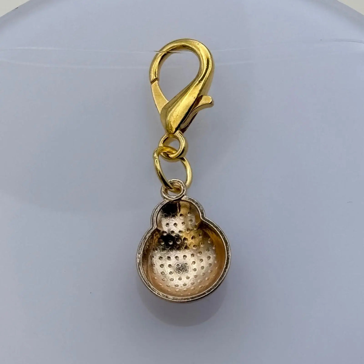 Bijou à accrocher de couleur dorée avec breloque coccinelle rouge à pois noir