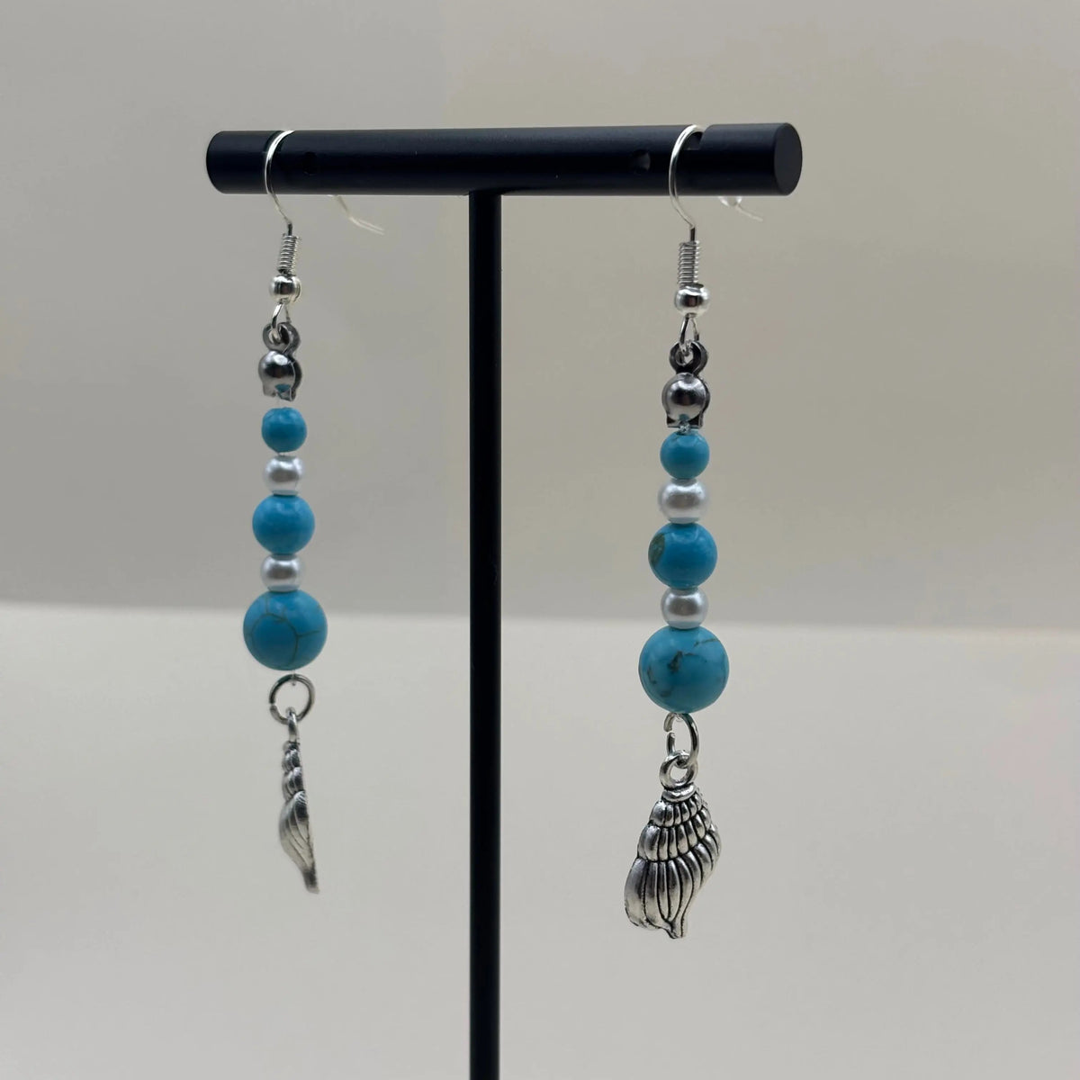 Boucles d'oreilles argentées avec breloque coquillage et perles bleues