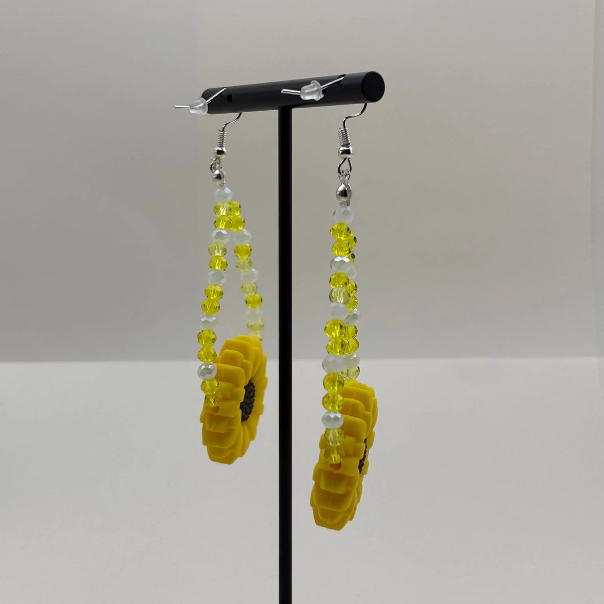 Une paire de boucles d'oreilles pendentif avec breloque marguerite jaune et perles acryliques