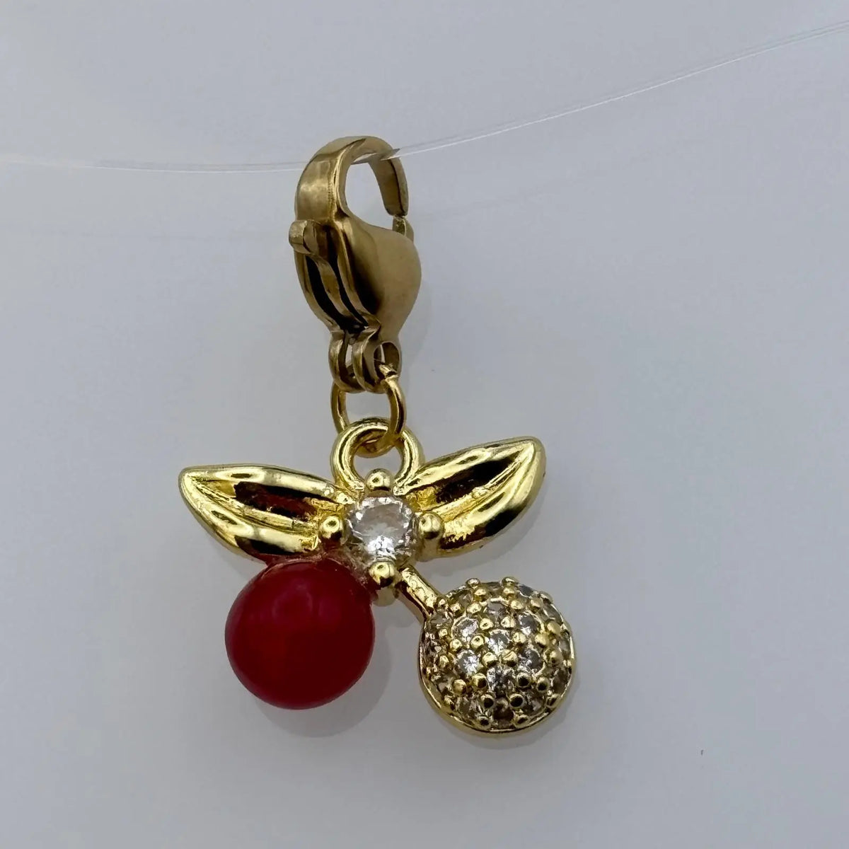 Bijou à accrocher doré avec breloque feuille dorée perles et strass et pastille rouge