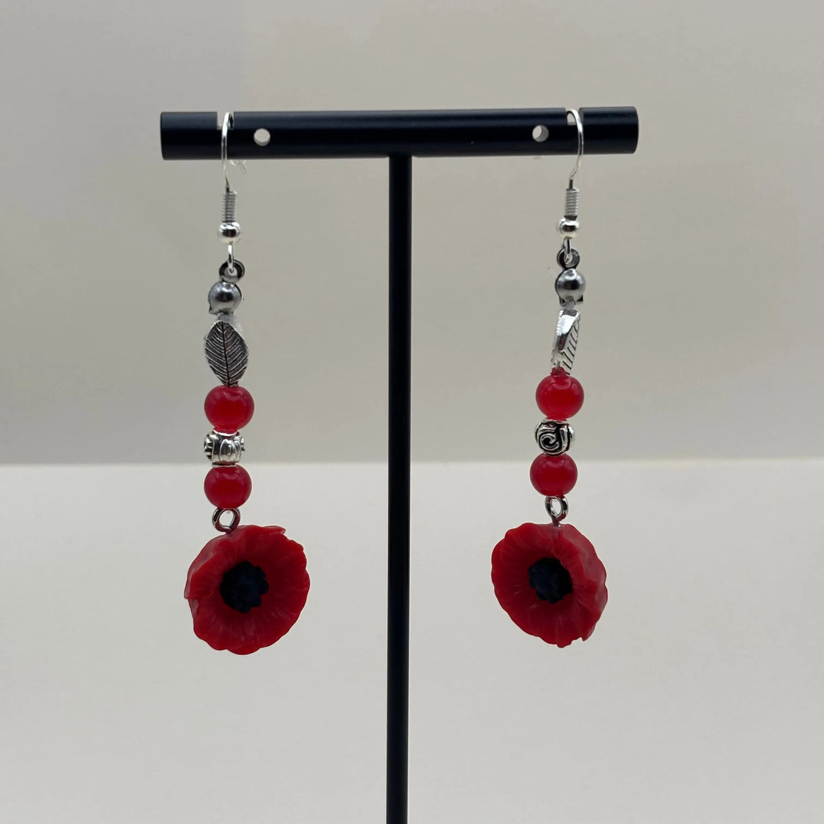 Boucles d’oreilles pendantes avec attache argentée  breloque fleur rouge et perles rouges et plumes argentées 