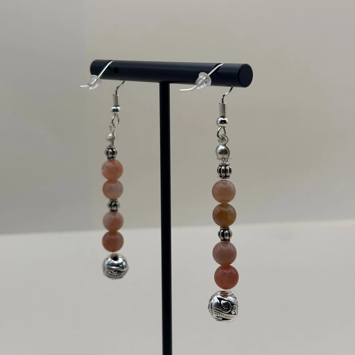 Des boucles d’oreilles pendantes avec attache argentée et perles marbrées et boule argentée 