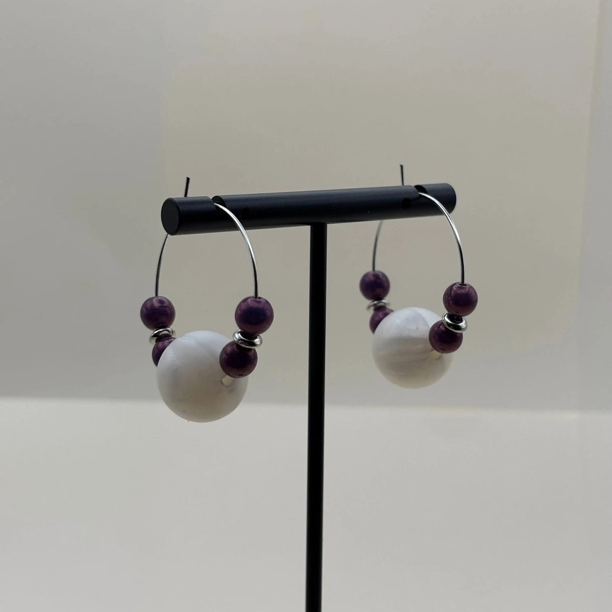 Boucles d’oreilles créoles argentées avec grosse perles blanche et quatre perles violettes