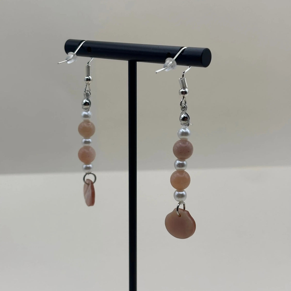 Des boucles d’oreilles pendantes avec attache argentée breloque coquille nacrée et perles blanches et pastels 