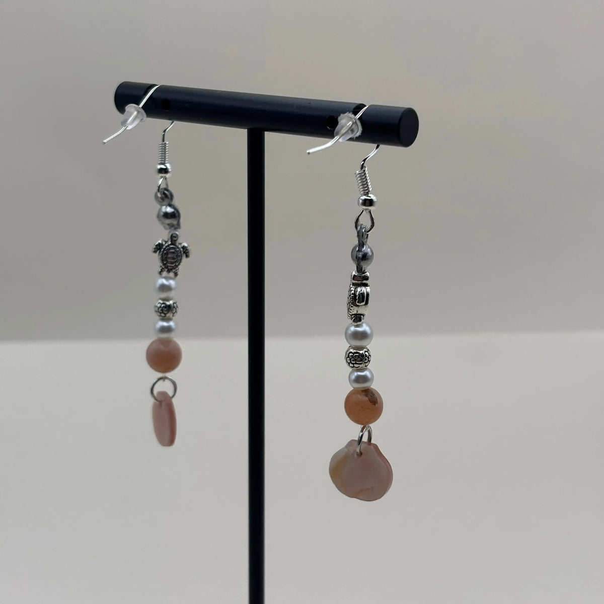 Des boucles d’oreilles pendantes avec attache argentée avec breloque coquille nacrée rose et tortues