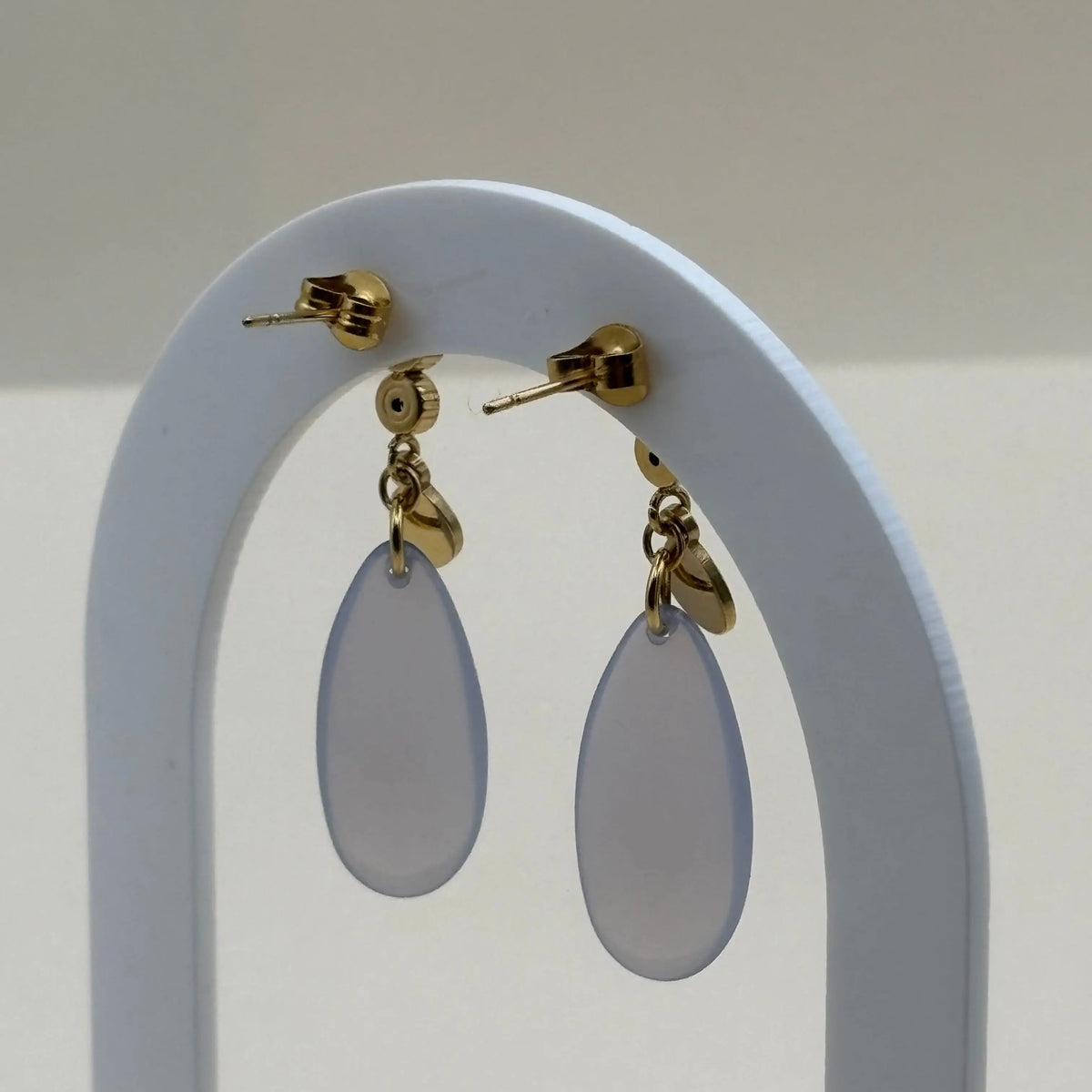 Une paire de boucles d'oreilles dorées avec motif goutte d'eau bleu en acier inoxydable 