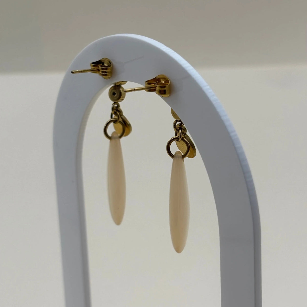 Une paire de Boucles d'oreilles dorées avec motif goutte d'eau écrue en acier inoxydable 