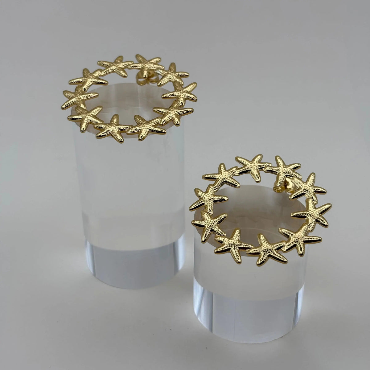 Une paire de boucles d'oreilles dorées ornées d'étoile de mer en cercle en acier inoxydable