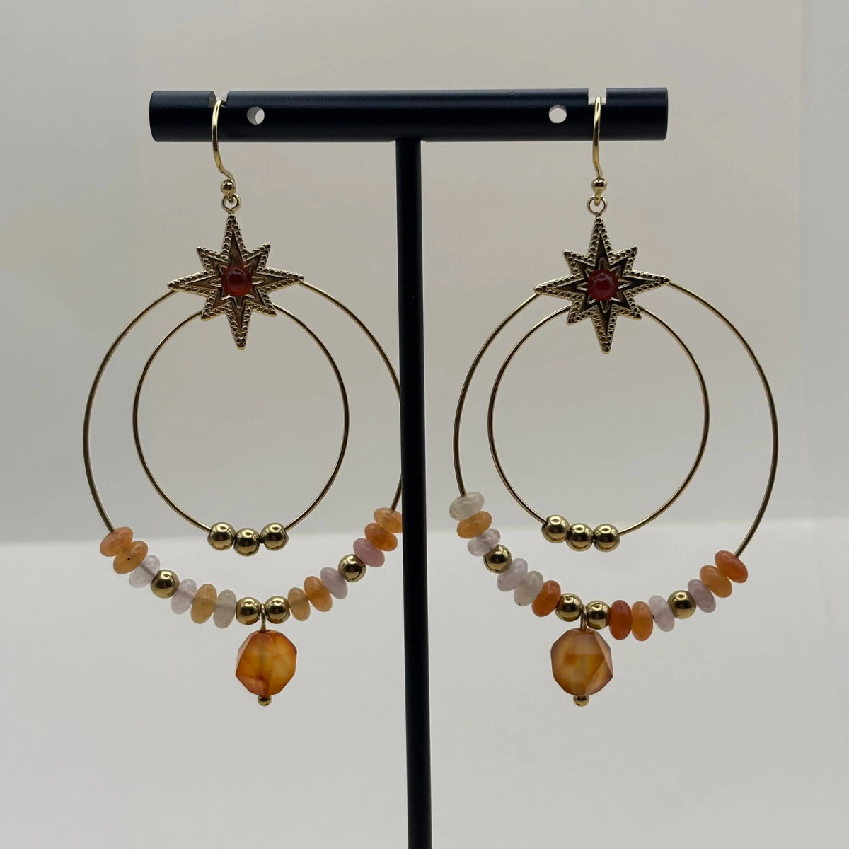 Boucles d’oreilles créoles dorées avec deux cercles ornés de pierres rouges et perles dorées