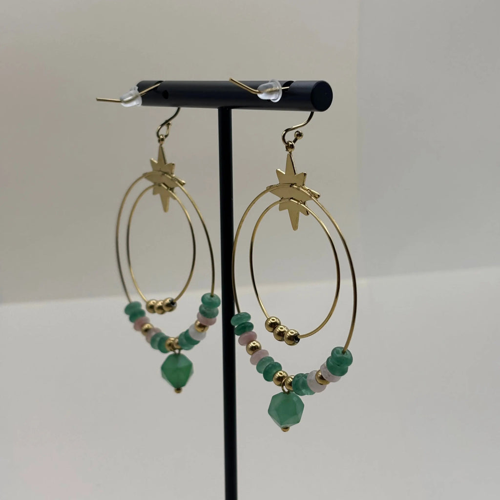 Des boucles d’oreilles créoles dorées avec deux cercles ornés de pierres vertes et perles dorées