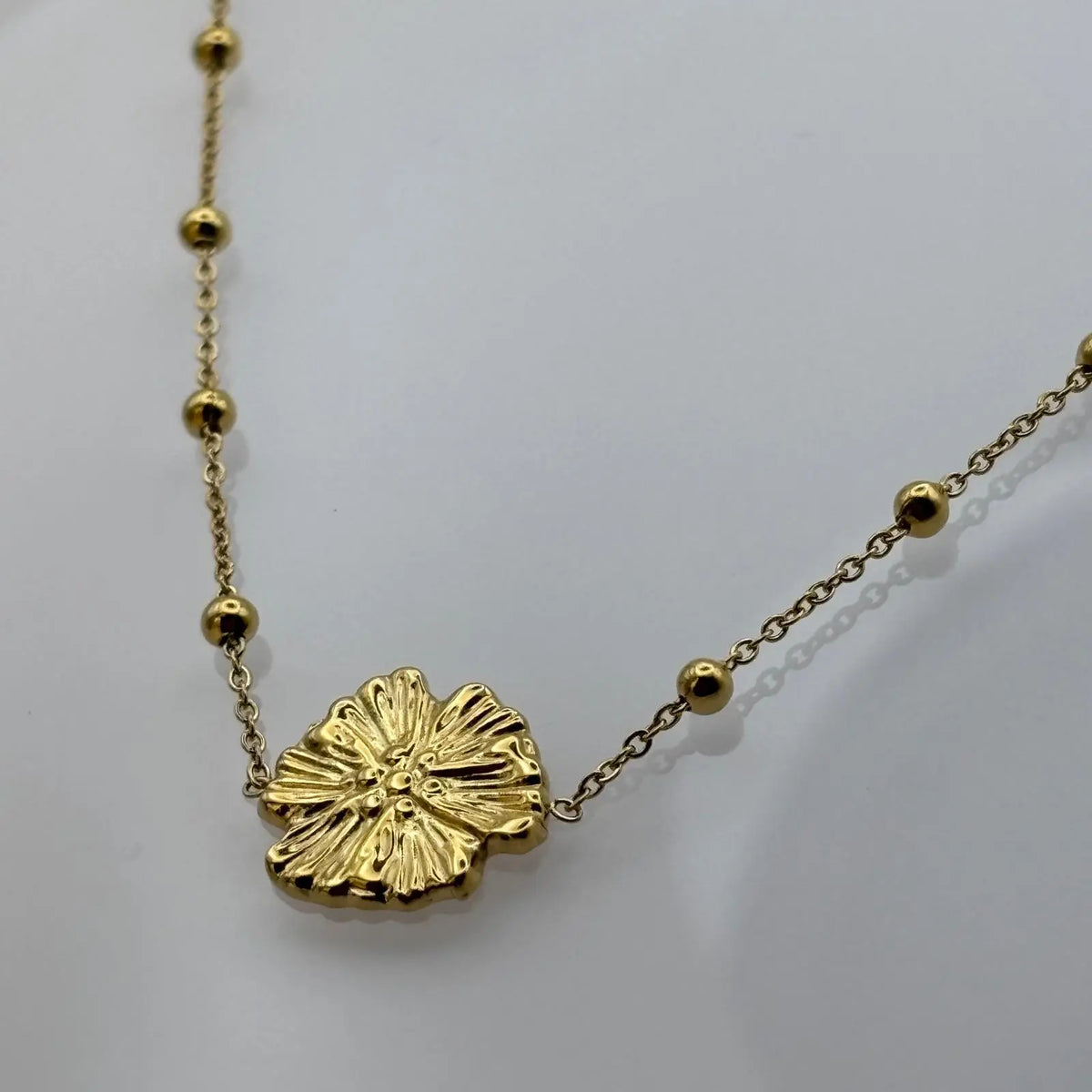 Bracelet doré et chainette avec perles dorées et fleur centrale en acier inoxydable