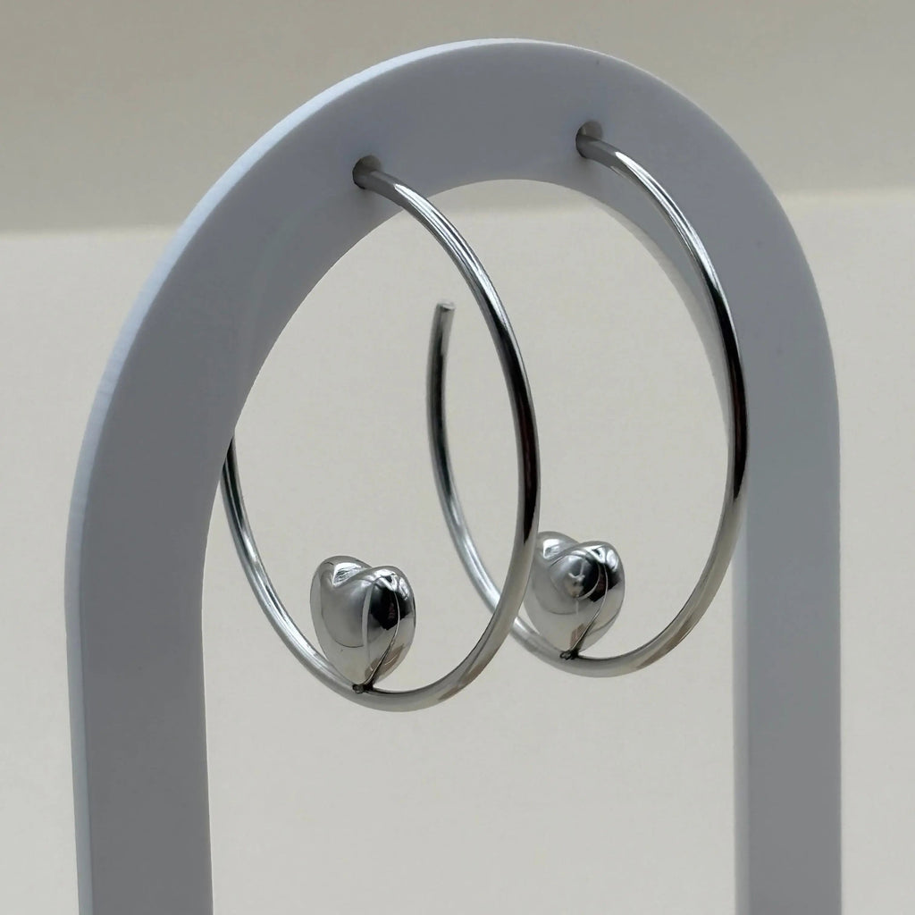 Des boucles d'oreilles créoles avec un motif en cœur argenté en acier 