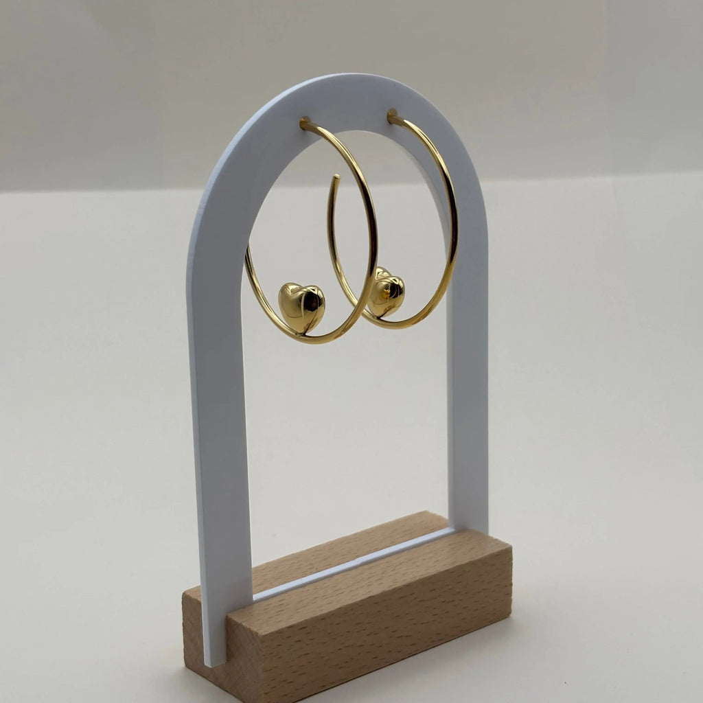 Des boucles d'oreilles créoles avec motif en cœur doré en acier inoxydable