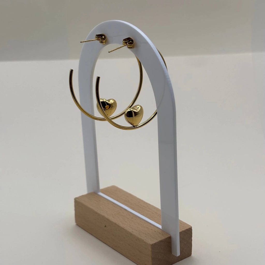 Une paire de boucles d'oreilles créoles avec motif en cœur doré en acier 