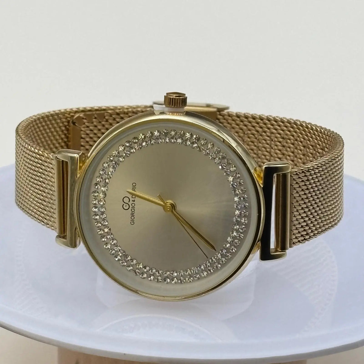 Montre pour femme bracelet doré cadran blanc irisé orné de strass sur le pourtour