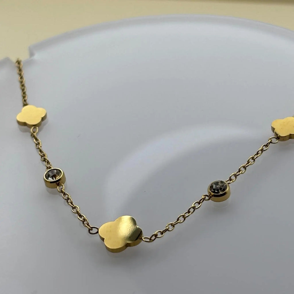 Bracelet doré avec breloques en forme de trèfles et des brillants en acier inoxydable