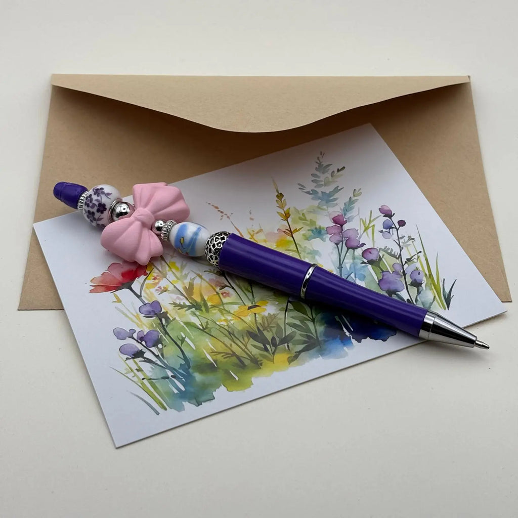 Stylo à bille à mine rétractable noire corps violet avec perles blanches beige et peinte