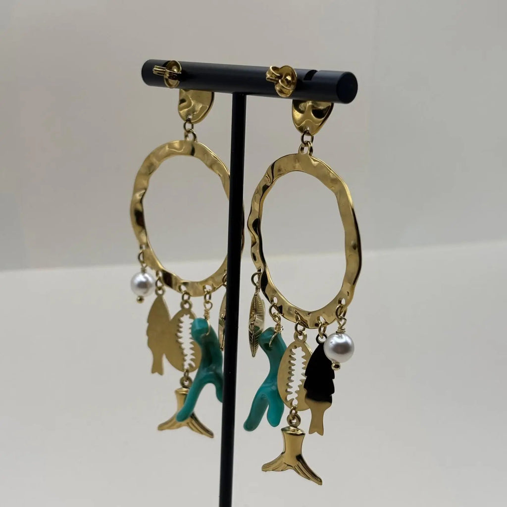 Des boucles d'oreilles dorées avec anneau et breloques turquoise étoile de mer coquillage