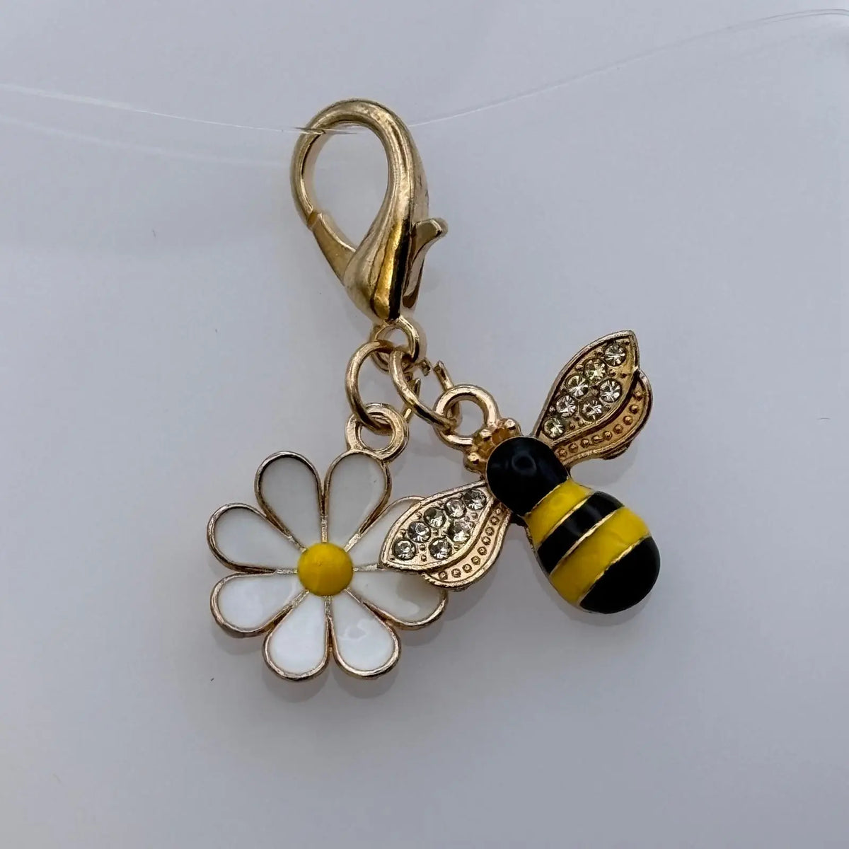 Bijou à accrocher doré avec breloque abeille et marguerite blanche