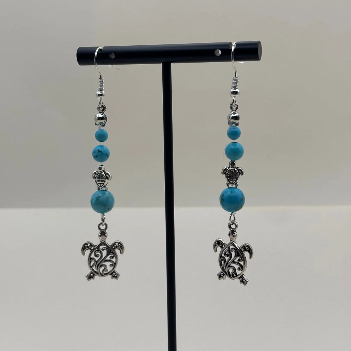 Boucles d’oreilles pendantes avec attache argentée avec breloque tortues et perles pastels bleues 