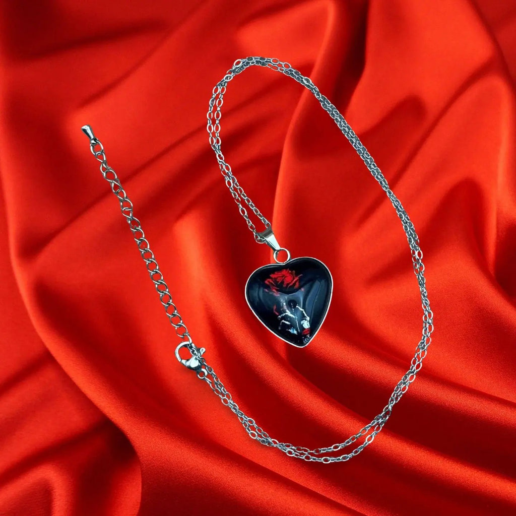 Pendentif halloween en forme de coeur noir avec une rose et une main squelette vendu sur le site pretes a briller