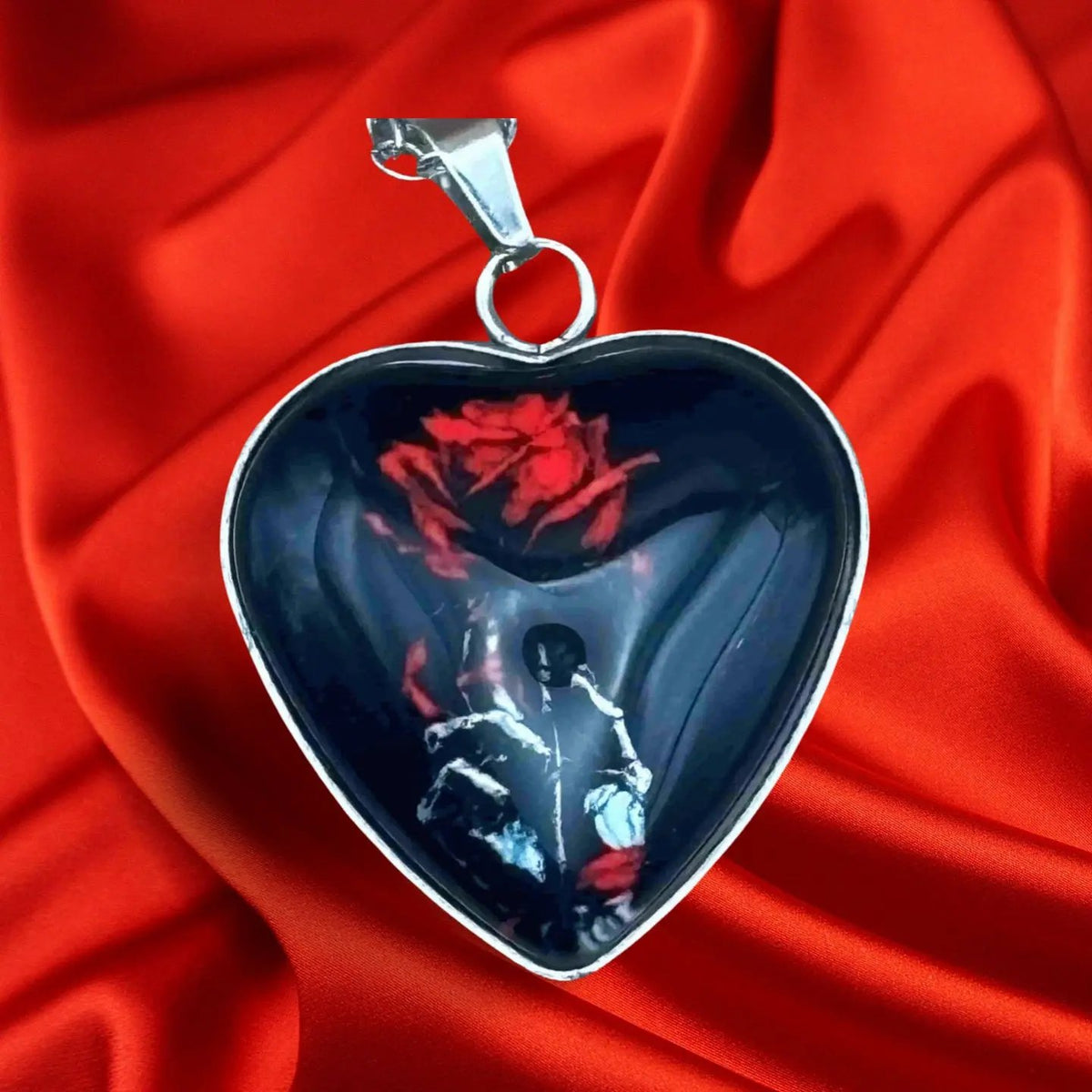 Pendentif pour halloween en forme de coeur noir avec une rose et une main squelette vendu sur le site pretes a briller