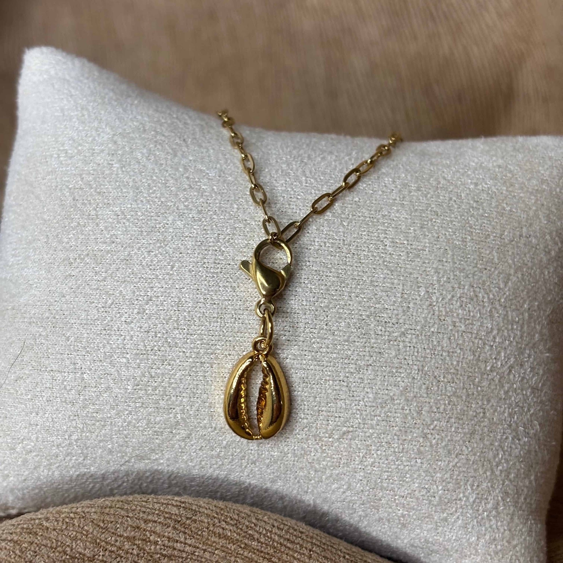 Bijou à accrocher doré avec une breloque en forme de coquillage vendu sur le site internet prêtes à briller