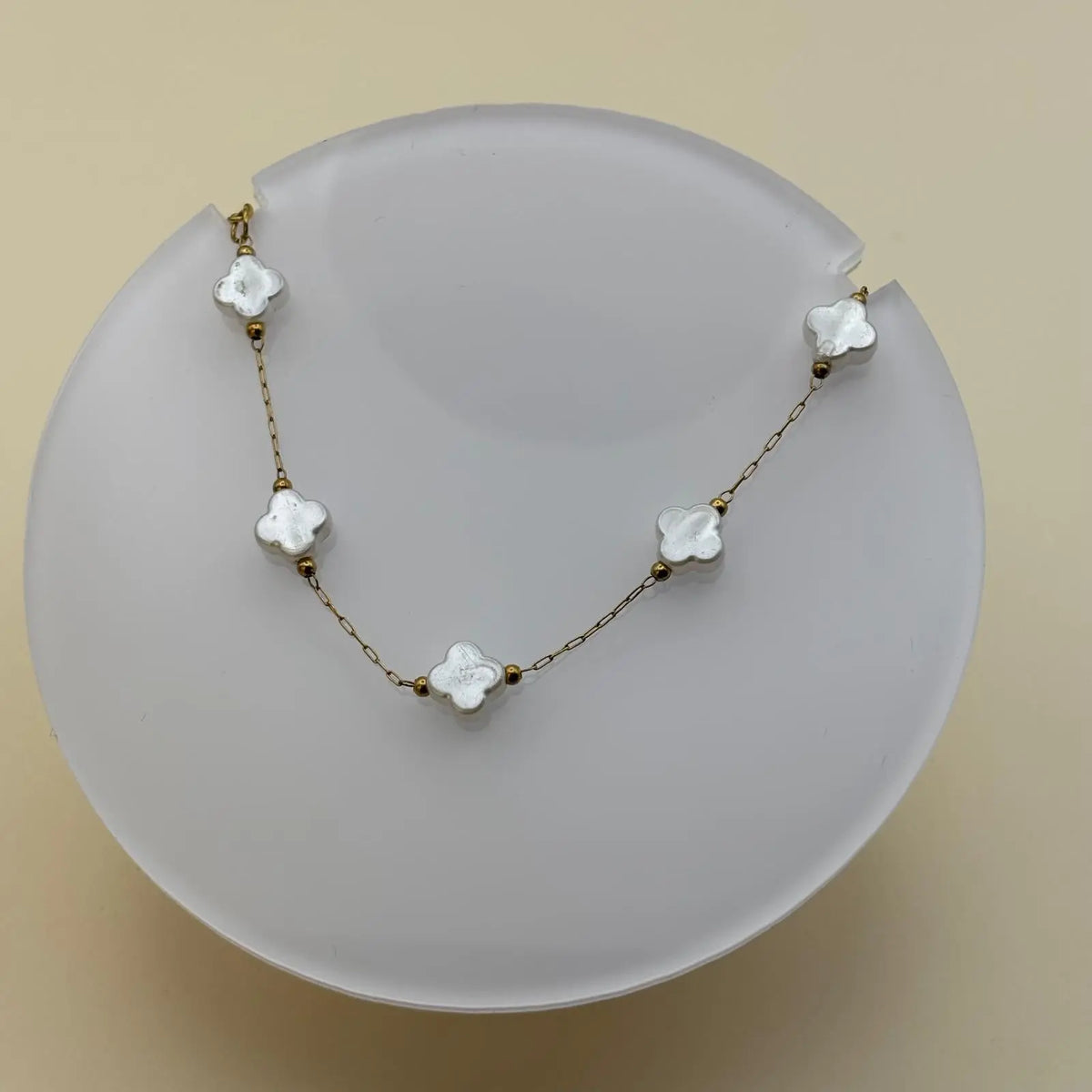 Bracelet doré avec petits maillons et breloques en forme de trèfles blanc nacrés