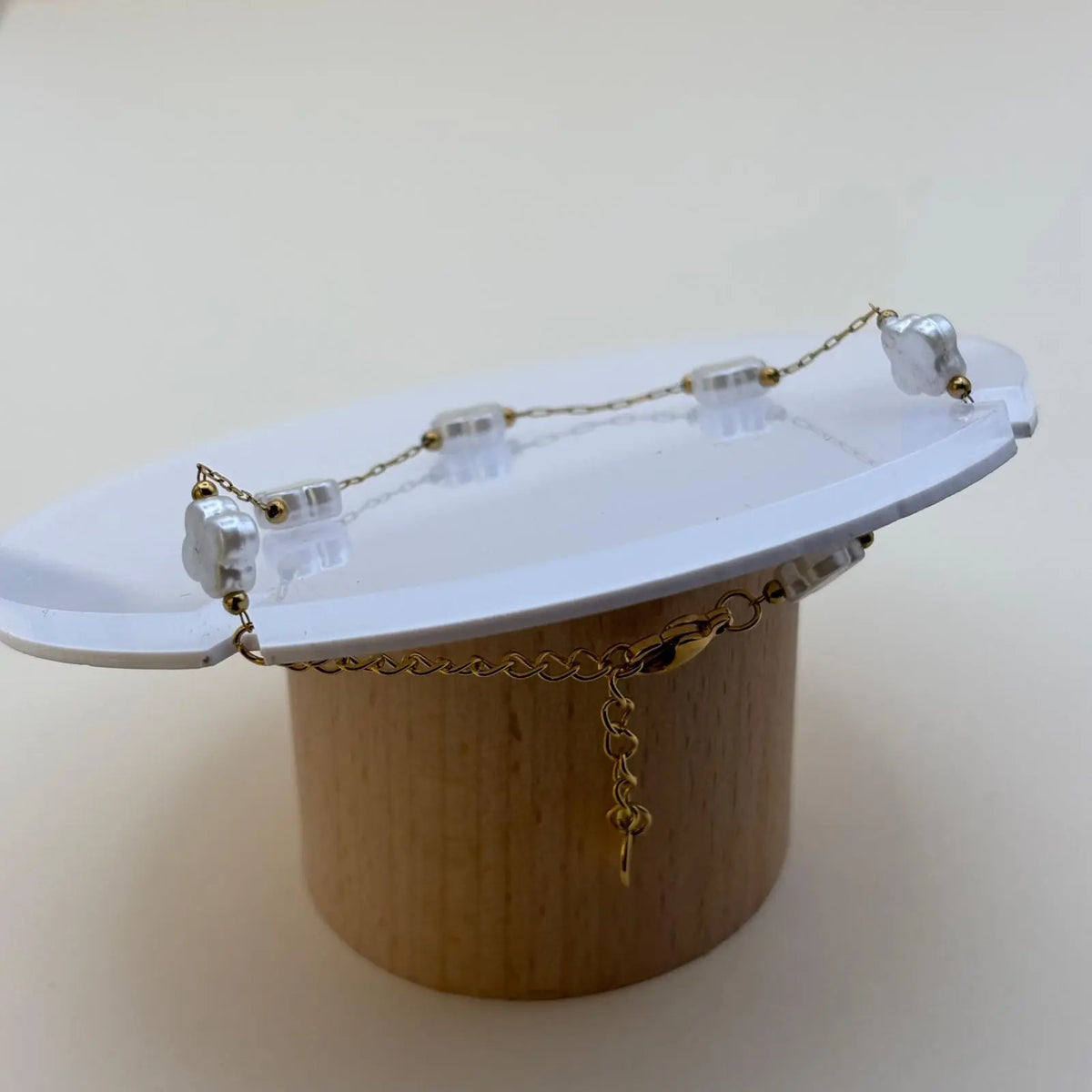 Bracelet doré avec petits maillons et des breloques en forme de trèfles blanc nacrés