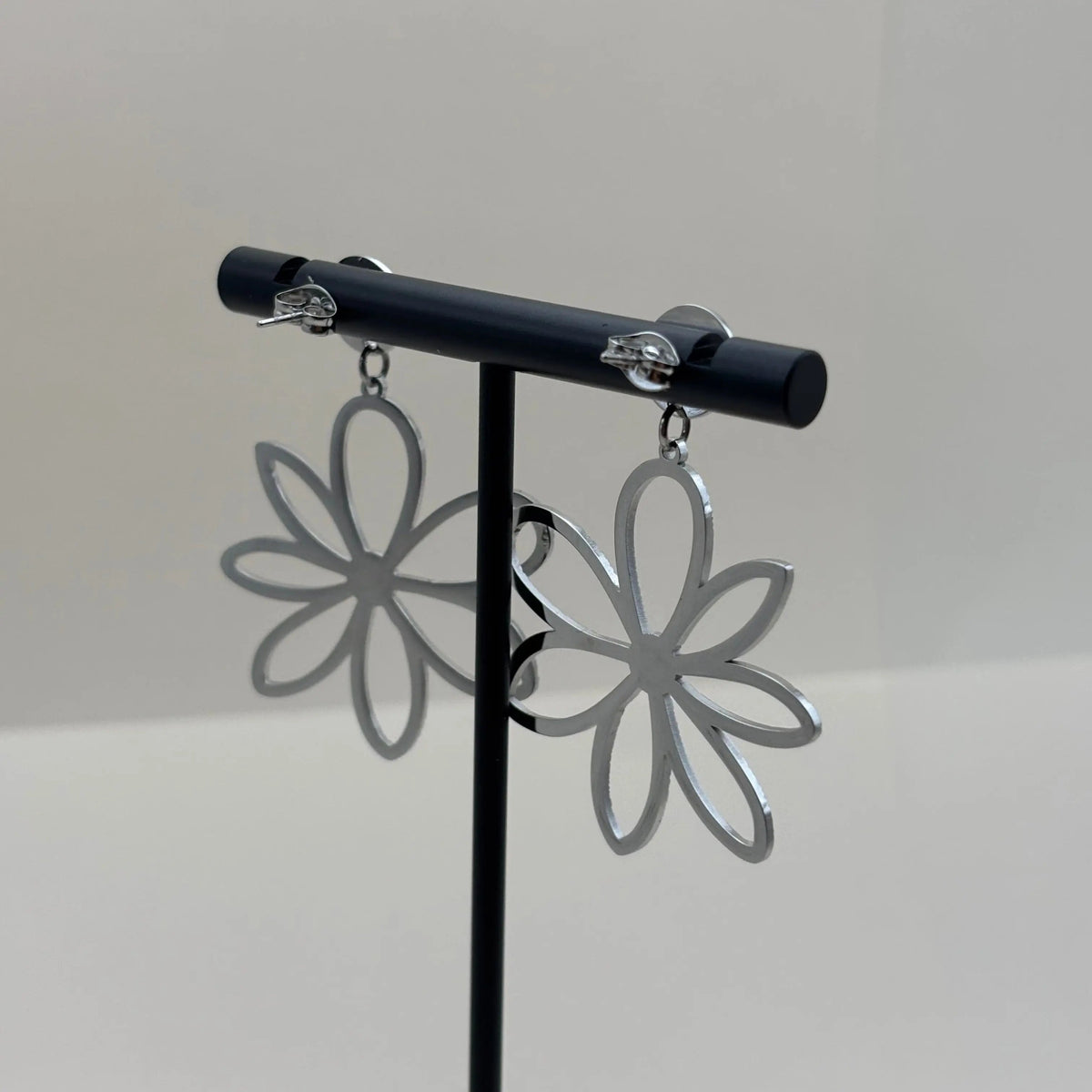 Des boucles d'oreilles argentées en pendentif en forme de fleur argentée en acier inoxydable