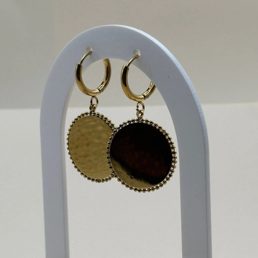 Des boucles d'oreilles dorée pendantes avec cercle dorée et pierre façon camé rouge