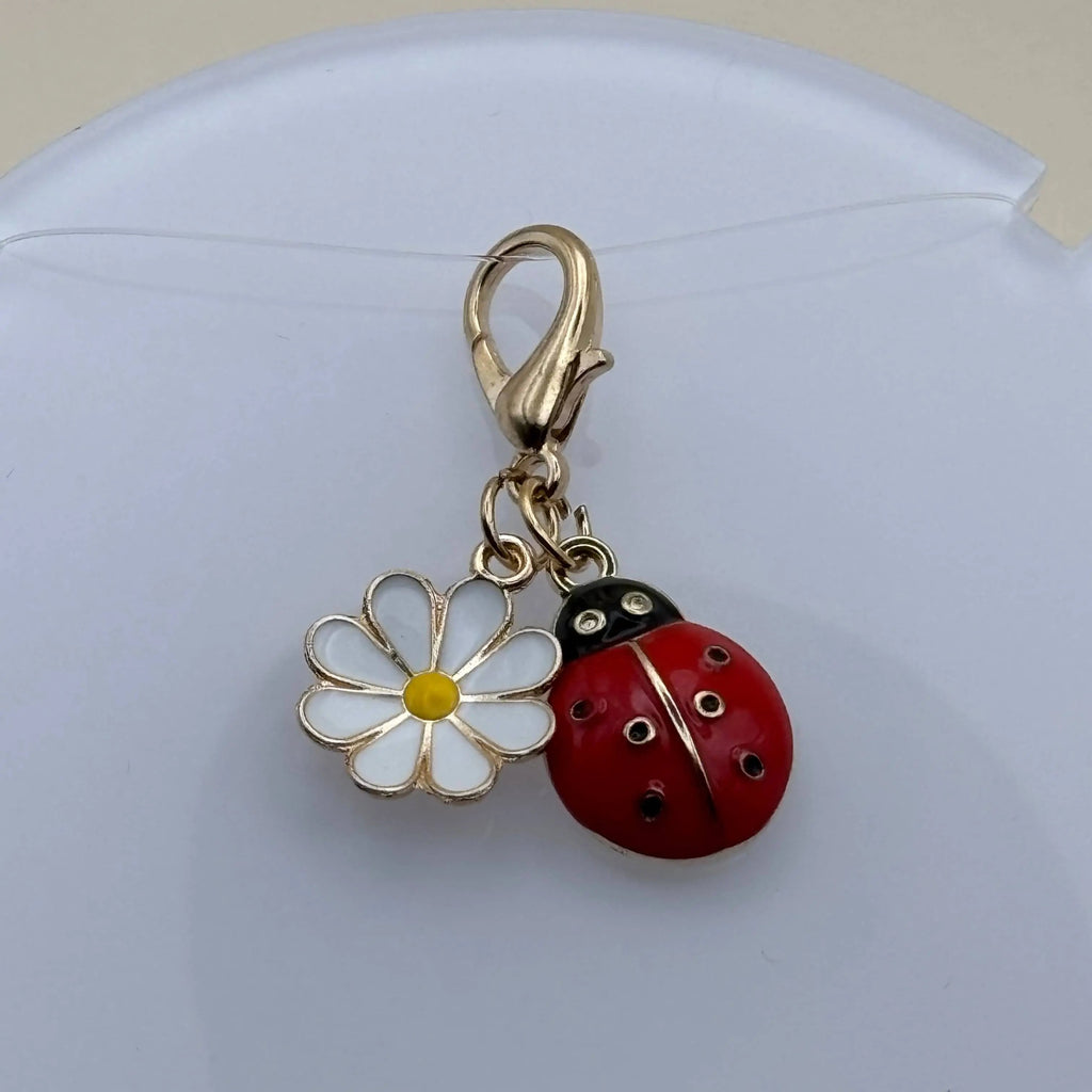 Bijou à accrocher avec attache dorée et breloque coccinelle et marguerite