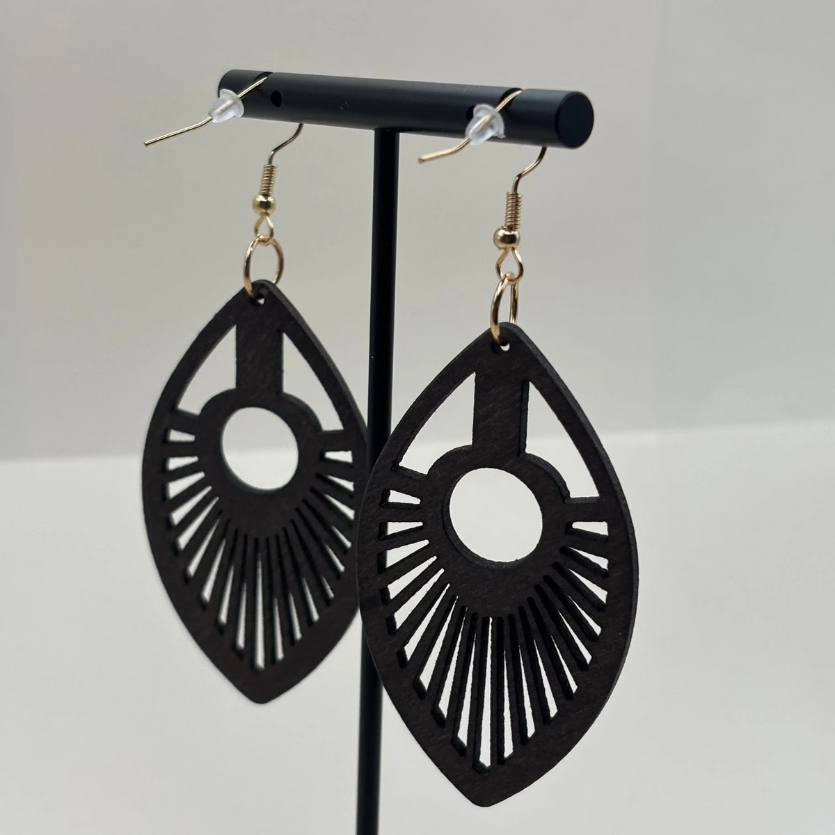 Des boucles d'oreilles avec attache dorée boucle en bois en forme de goutte d'eau et motif ajouré