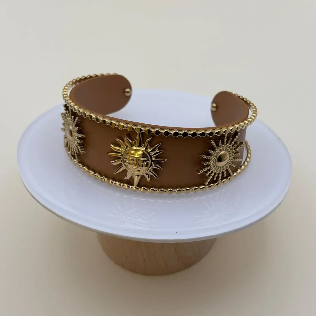 Bracelet rigide ouvert de couleur marron avec soleils dorées et perles dorées