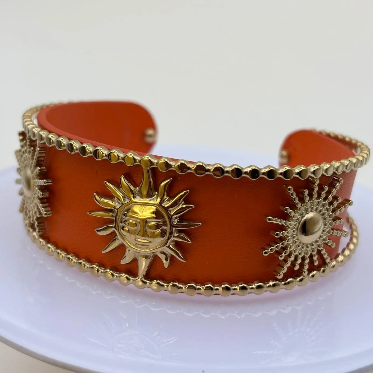 Bracelet rigide ouvert de couleur orange avec soleils dorées et perles dorées